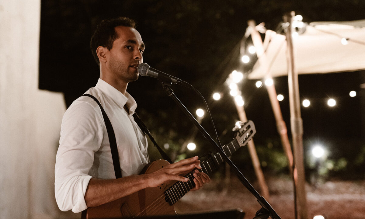 Khalil met gitaar in witte blouse