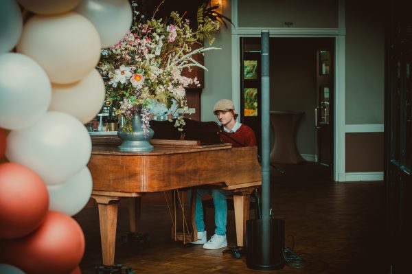Tom zit achter piano en zingt tijdens een bruiloft