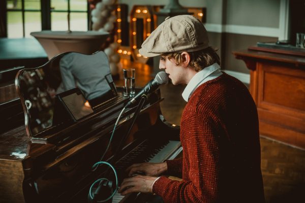 Tom zit achter piano en zingt tijdens een bruiloft