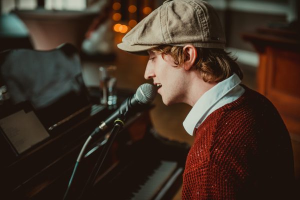 Tom zit achter piano en zingt tijdens een bruiloft