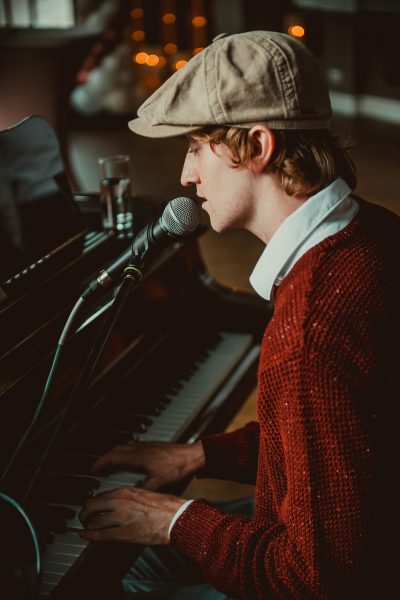 Tom zit achter piano en zingt tijdens een bruiloft