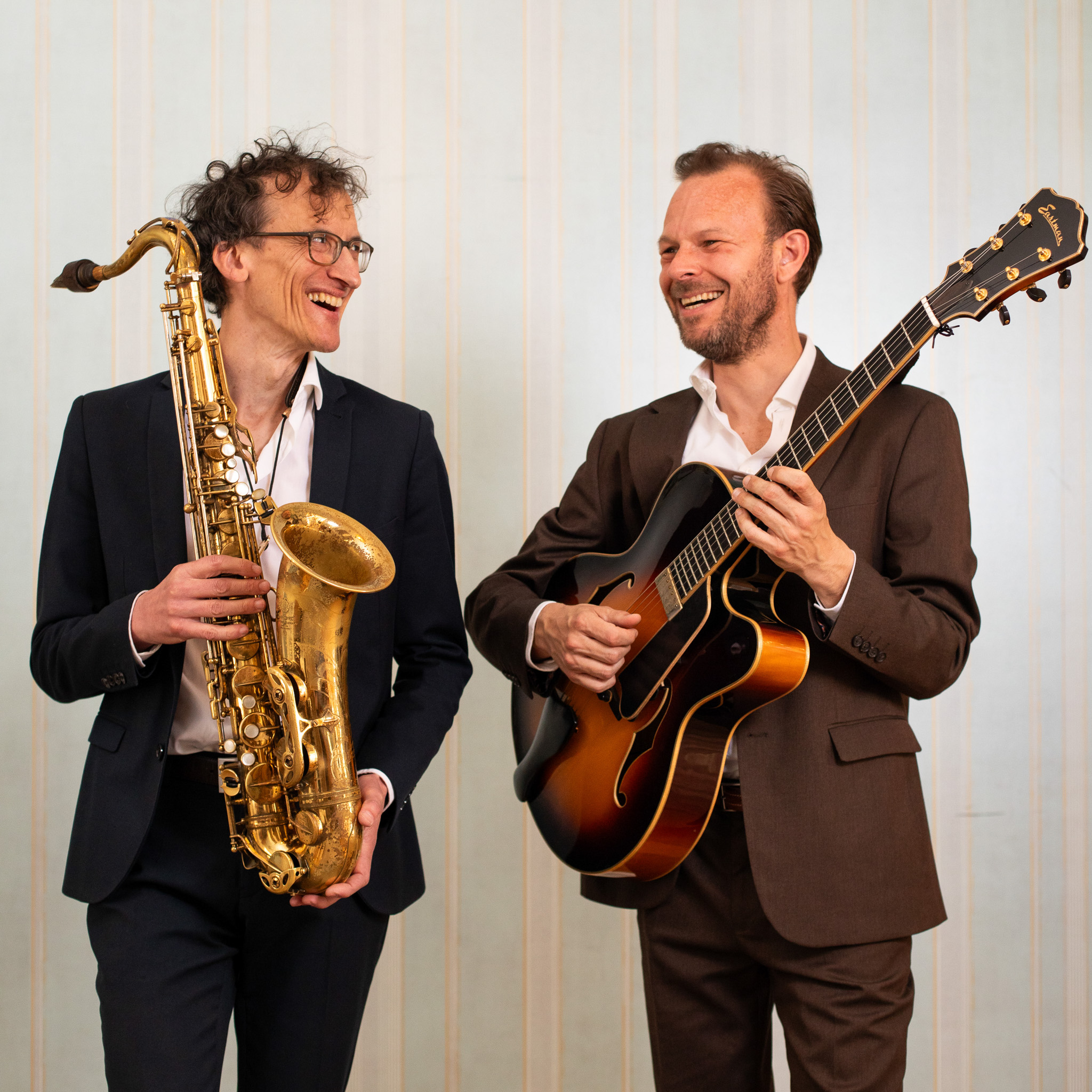 Gitarist Wouter en Saxofonist Iman poseren met instrument.